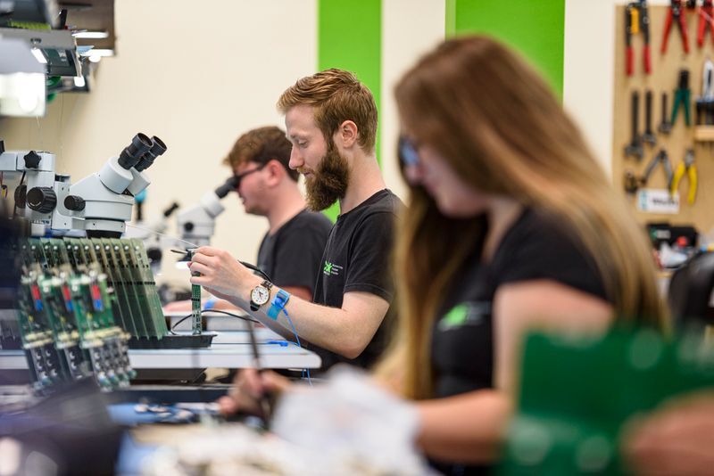 Production engineers at work producing electronic devices.